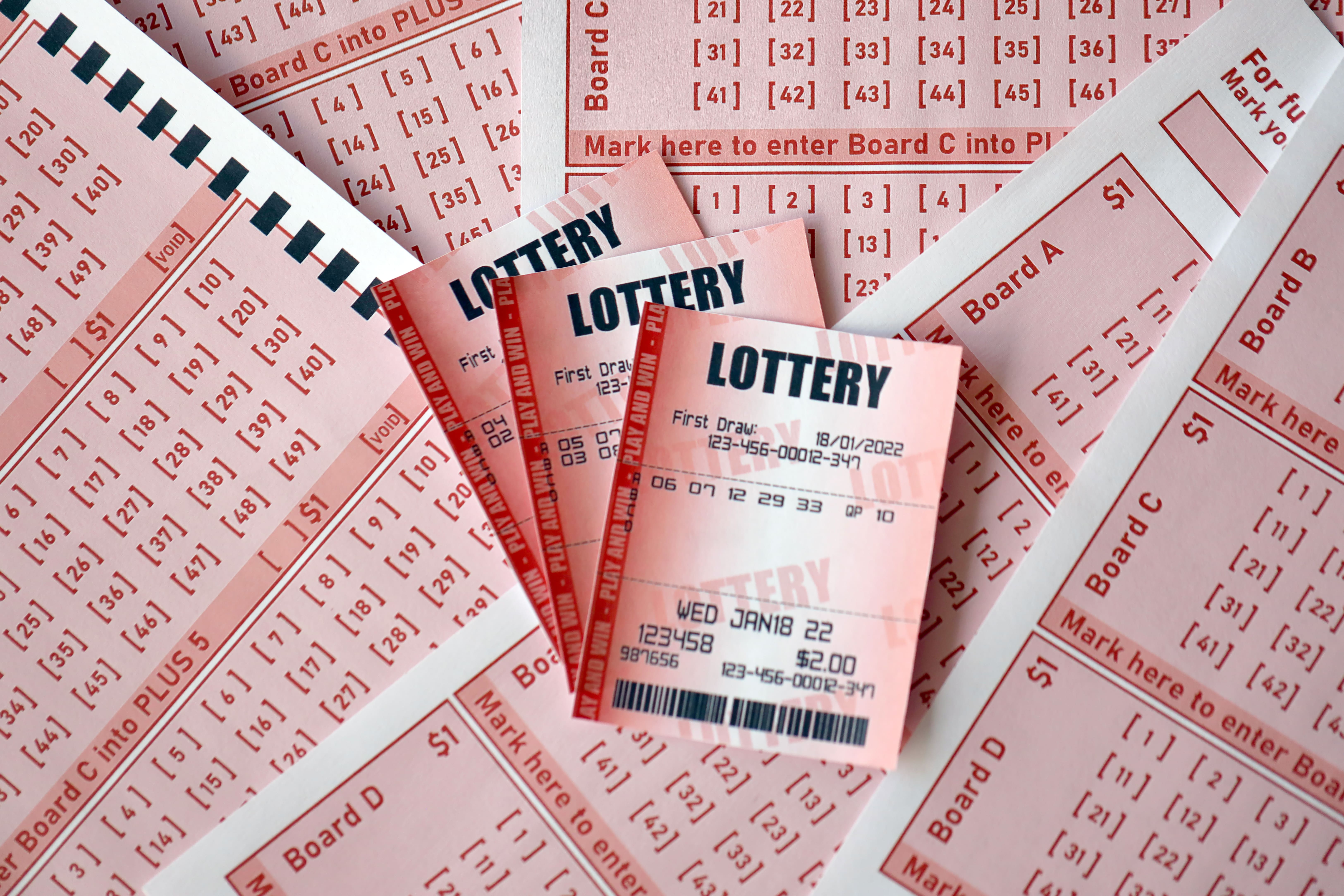 Varias personas celebrando con boletos de loteria nacional y loteria de navidad en las manos, confeti y ambiente alegre.